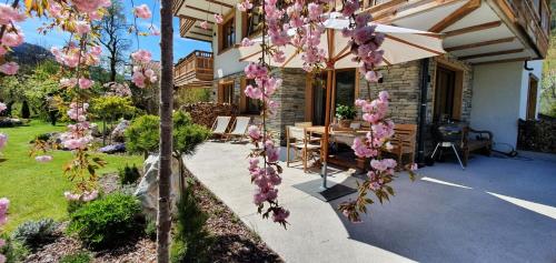 a garden with pink flowers hanging from a building at Rocks Schladming in Schladming