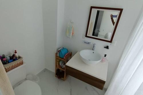 uma casa de banho branca com um lavatório e um espelho em Acapulco Diamante Banus Residencial em Acapulco