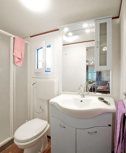 a white bathroom with a toilet and a sink at Camping Village Rosselba Le Palme in Portoferraio