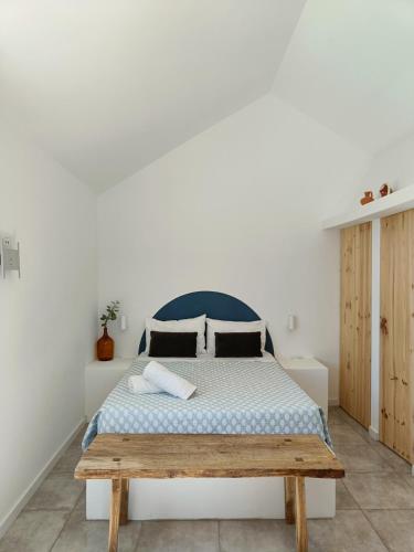 a bedroom with a bed and a wooden bench at Casinhas Vale de Mouro in Melides
