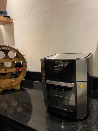 a microwave sitting on a counter next to a basket at Chalé lindo para toda família nas montanhas !!! in Domingos Martins
