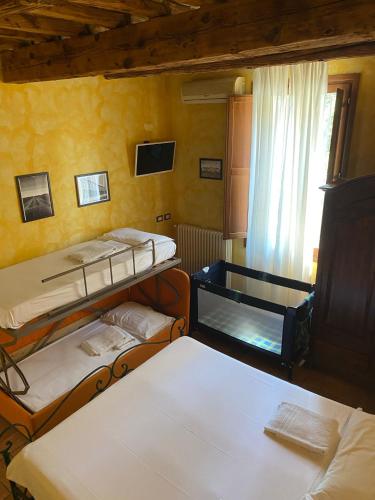 a room with three bunk beds and a window at La Vecchia Stazione Ravenna in Ravenna