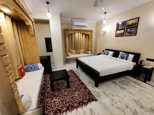 1 dormitorio con 1 cama blanca grande y espejo en Hotel Vasshifa Palace, en Jaisalmer