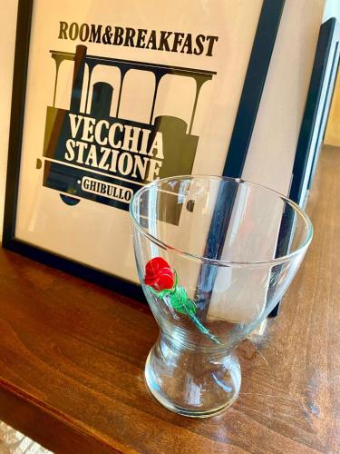 a glass cup sitting on a table next to a book at La Vecchia Stazione Ravenna in Ravenna
