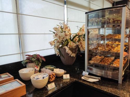 a bakery counter with pastries in a display case at Reymar Hotel Maceió in Maceió