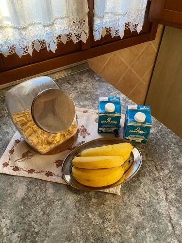 a counter with a bowl of bananas and some milk at La Vecchia Stazione Ravenna in Ravenna