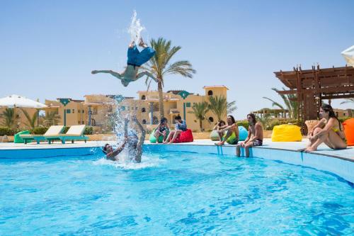 un groupe de personnes regardant une personne sauter dans une piscine dans l'établissement Green Sudr Resort, à Ras Sudr