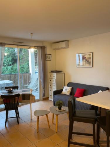 un salon avec un canapé et une table dans l'établissement Joli appartement tout confort, à Hyères