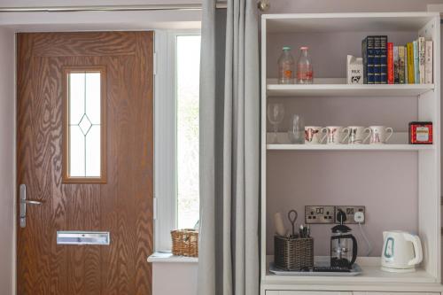a room with a door and a shelf with books at The Costrel in Tenbury