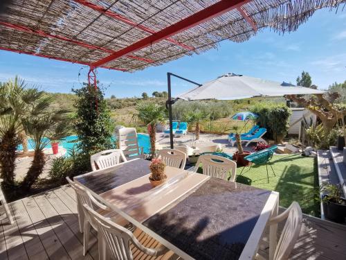 un patio avec une table, des chaises et un parasol dans l'établissement Studio Camille, à Sainte-Vallière