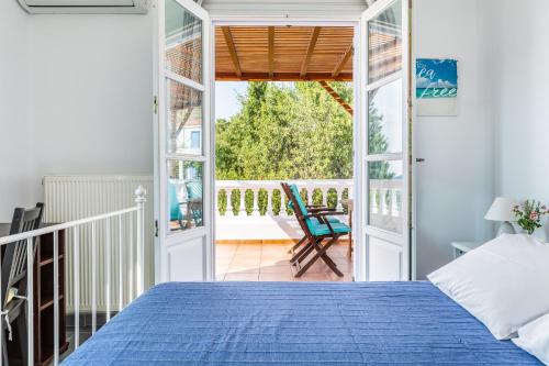 a bedroom with a blue bed and a balcony at Villa Rodia with swimming pool on Skopelos Island in Skopelos Town