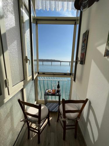 a balcony with two chairs and a table with a view of the ocean at Bombonera apartment in Augusta