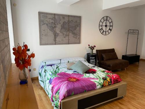 una camera da letto con un letto con una coperta a motivi floreali di Una finestra sul centro storico a Reggio Emilia