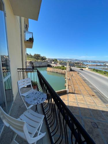 two chairs sitting on the balcony of a building at Bombonera apartment in Augusta