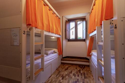 a room with two bunk beds and a window at El Albergue de Sigüenza in Sigüenza