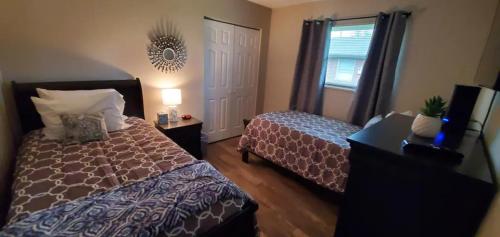 1 dormitorio con 2 camas, ventana y espejo en A great newly renovated place to stay in Franklin, en Franklin