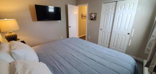 1 dormitorio con 1 cama azul y TV en la pared en A great newly renovated place to stay in Franklin, en Franklin