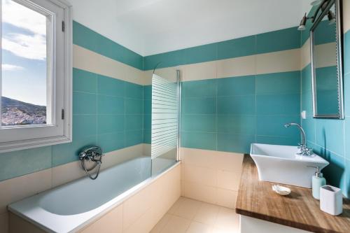 a bathroom with a tub and a sink at Villa Rodia with swimming pool on Skopelos Island in Skopelos Town