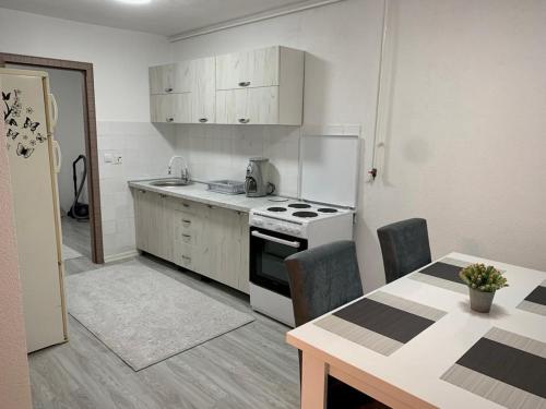 uma cozinha com um fogão, um frigorífico e uma mesa em Apartman SelmaM em Sarajevo