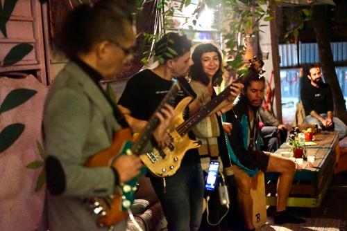 a group of people playing guitars in a room at Good People Design Hostel in Belgrade