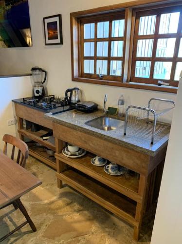 a kitchen with a sink and a counter top at Morada Sunset Vista Para o Mar in Praia do Rosa
