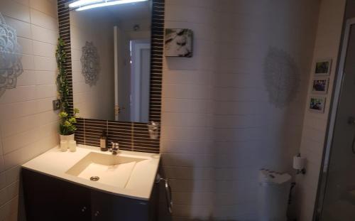 a bathroom with a sink and a mirror at El BALCÓN de PILAR in Zaragoza
