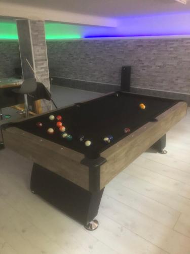 a black pool table with balls in a room at Villa del catalunya in Perpignan