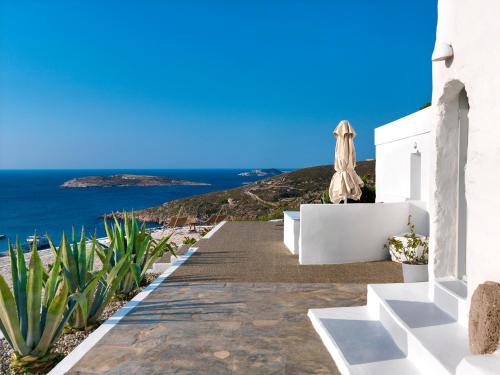 a path leading to a white house with an umbrella at The Windmill Kimolos in Kimolos