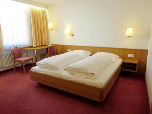 a bedroom with a large bed with two pillows at Hotel Find in Stuttgart