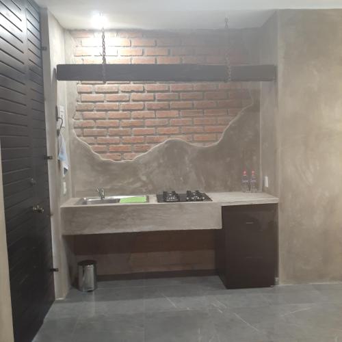 a bathroom with a sink and a brick wall at Loft con Jardín amplio 3 in Puerto Vallarta