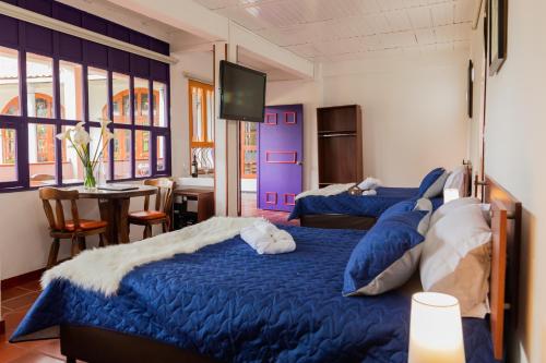 two beds in a room with purple walls and a table at hotel villa claudia in Nobsa