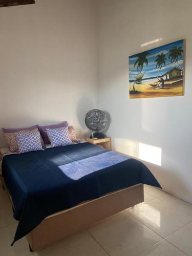a bedroom with a bed with a blue comforter at Pousada Vila do Mar in Taíba