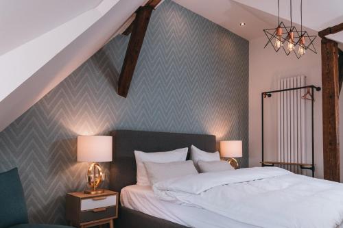 a bedroom with a bed and two night stands with lamps at Boutique-Hotel Anno 1910 in Wernigerode