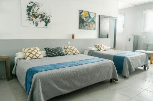 a bedroom with two beds and a couch in it at Paz-2 Norte estudios in Playa del Carmen