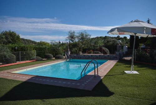 a large swimming pool with an umbrella and an umbrella at VILLA BASILIO in Constantina