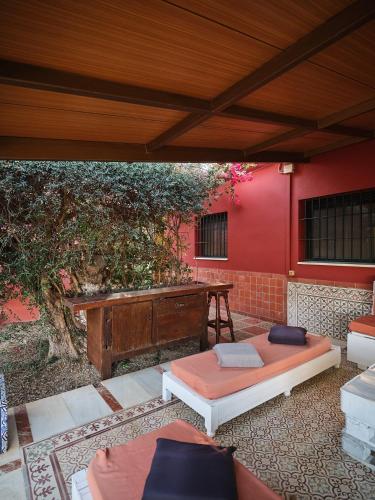 a patio with two beds and a red wall at VILLA BASILIO in Constantina