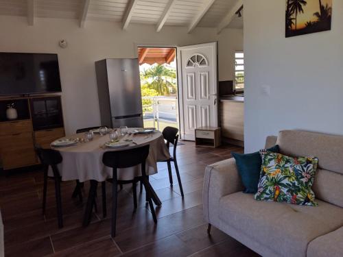 una sala da pranzo con un tavolo e un divano di Villa Papillon a Saint-François