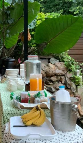 a table with a plate of bananas and orange juice at Saythong boutique hotel in Chiang Khan