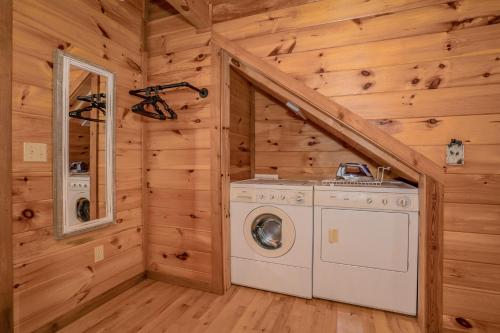 eine Waschküche mit Waschmaschine und Trockner in einem Blockhaus in der Unterkunft Gone To Therapy in Sevierville