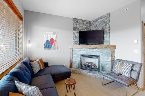 a living room with a blue couch and a fireplace at Bears Paw 5 in Big White