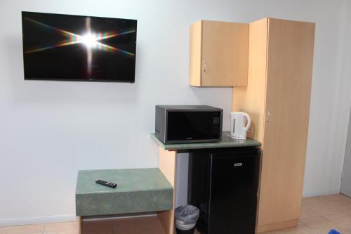 a room with a microwave and a computer on a wall at TI Motel Torres Strait in Thursday Island