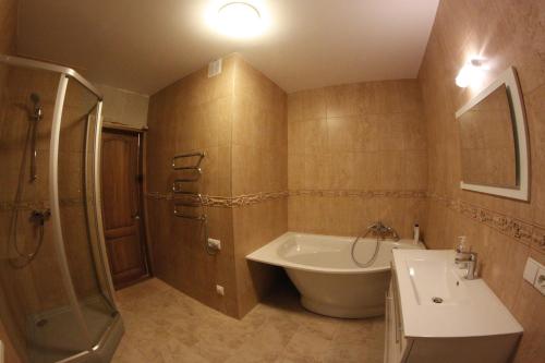 a bathroom with a tub and a sink and a shower at Elena in Palanga