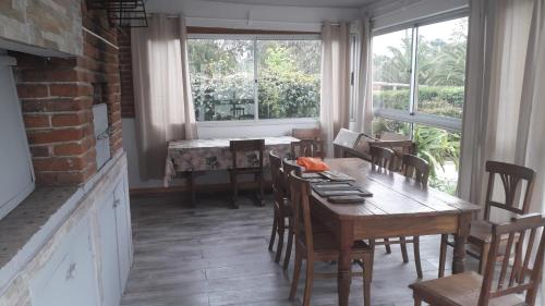 a dining room with a table and chairs and a window at Acogedora casa en barrio tranquilo de Piriápolis in Piriápolis