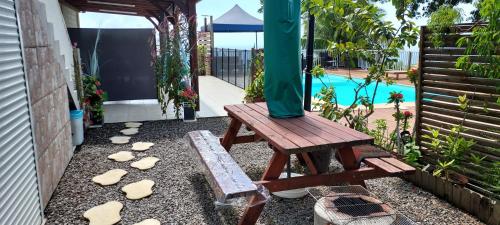 a picnic table and a bench in a backyard at Les hauts du fromager in Le Diamant