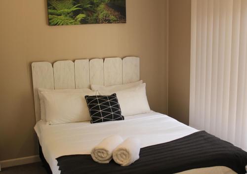 a bedroom with a bed with two towels on it at Snow Gum Apartment 1 in Baw Baw Village