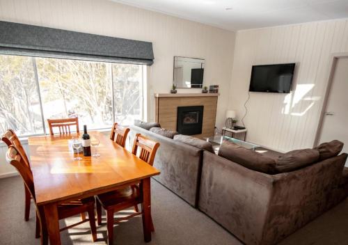 a living room with a large couch and a table with a tableablish at Snow Gum Apartment 1 in Baw Baw Village