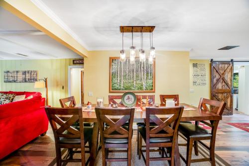 a dining room with a table and a red couch at 6 Bedroom House at Schroon River in Brant Lake