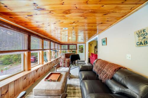a living room with a couch and some windows at 6 Bedroom House at Schroon River in Brant Lake