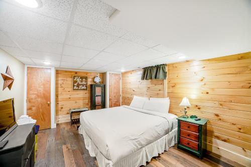 a bedroom with a white bed and a television at 6 Bedroom House at Schroon River in Brant Lake