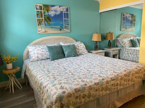 um quarto com uma cama grande e paredes azuis em Treasure Island 1BR Beach condo with Gulf View em St. Pete Beach
